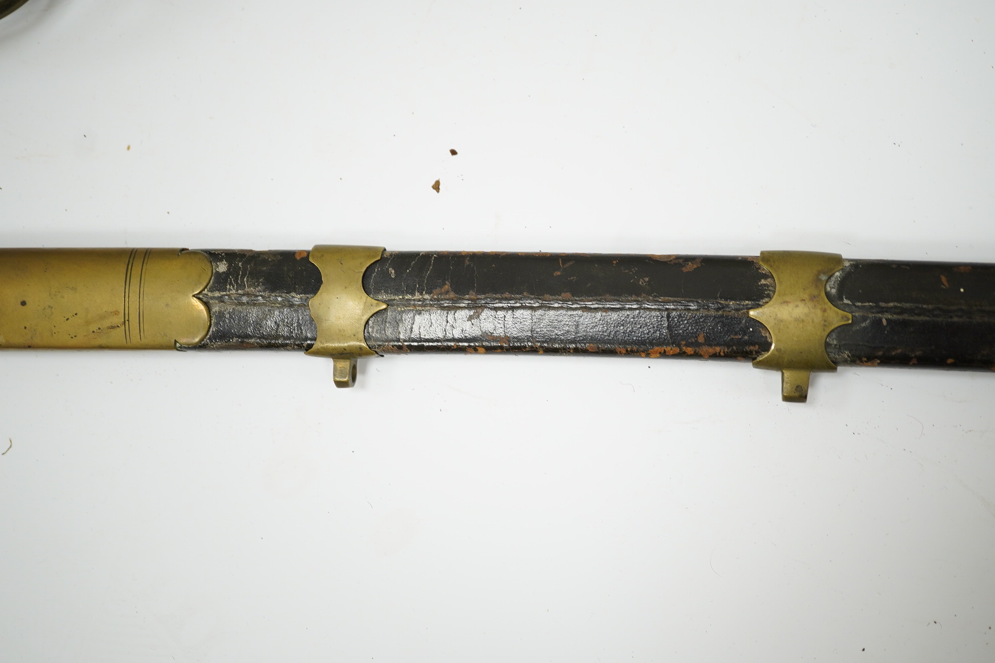 An 1845 pattern infantry officer’s sword, with plain slightly curved blade, regulation solid brass guard, and wire bound fish covered grip, in its brass mounted leather scabbard. Condition - poor to fair, blade cleaned b